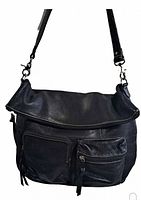 Front view of the black pebble leather shoulder bag showing fold-over flap and front zippered pockets.