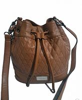 Front view of brown diamond quilted leather crossbody bag with drawstring closure and attached shoulder strap.