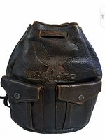 Front view of brown leather sling backpack showing embossed US Air Force eagle logo and two flap snap pockets.