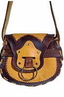 Front view of yellow and brown saddle leather bag with metal ring closure and detailed leather stitching.