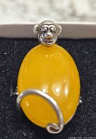 Front view of the sterling silver monkey cocktail ring showing the yellow jade oval cabochon and the monkey head detail.