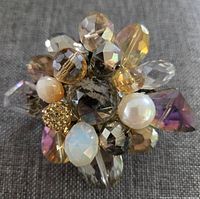 Close-up of the front of Ali Khan crystal and bead brooch showing multiple faceted beads and pearls in a clustered design.