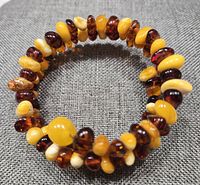 Close-up photo of adjustable memory wire Baltic amber bracelet showing the mixed honey yellow and creamy colored beads on flexible wire.