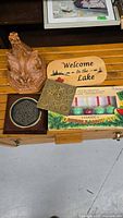Top view of assorted items including wooden rooster plaque, welcome sign, tic-tac-toe pieces, classic bubble night light set, and circular maze puzzle.