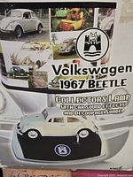 Box showing decoupage lamp shade with images of 1967 Volkswagen Beetle cars and text describing collector's lamp with sound effects.
