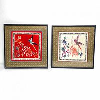 Pair of framed antique Chinese silk embroidery panels with bird and floral designs shown side by side.