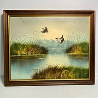 Full view of the framed oil painting showing the marsh, ducks, and surrounding reeds with a water reflection, signature visible at bottom left.