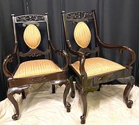 Pair of early 1900s Queen Anne style wooden chairs with carved details and upholstered seats and backs in checked beige fabric.