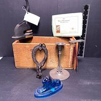 Antique metal embosser, old cigarette box, metal paper holder, wooden box, pewter candle holder, blue glass lion paperweight arranged together