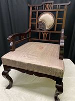 Front-left angle view of antique rosewood pagoda chair showing the half moon design in the backrest and fabric stained seat upholstery.