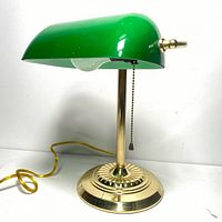 Front side view of vintage desk lamp showing green glass shade, brass base, and pull chain.