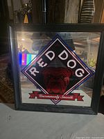 Framed mirrored beer advertisement sign showing Red Dog brand and 'Uncommonly Smooth' tagline