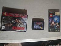 Photo shows the three games: boxed Sega Genesis Cliffhanger, Dracula cartridge, LEGO Harry Potter PSP UMD in case.