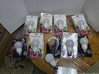 Nine Feit Electric LED Party light bulbs displayed on a table; seven boxed and two loose bulbs visible.