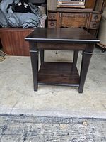 Full view of the brown wooden end table showing the design, finish, and overall condition.