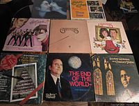 Top view of all eight vinyl record album covers laid out on a flat surface showing various artists and titles