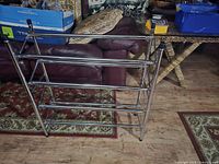 Front view of metal shoe rack showing five horizontal bars and side frame structure.