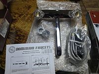 New Dominion kitchen faucet with packaging, installation instructions, and faucet components laid out on bubble wrap.