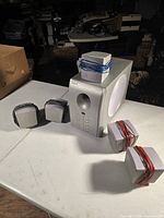 Photo showing main subwoofer unit with five satellite speakers arranged on table.