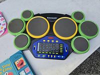 Close-up photo of green and yellow Kawasaki electronic drum set with pads and digital control panel