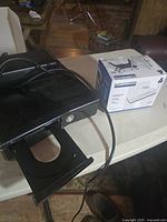 Xbox 360 console with open disc tray and 2.4G wireless receiver box on a table.