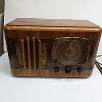 Full view of the 1930s General Electric Model F62 vintage radio with wood cabinet, fabric speaker grille, and Catlin face cover.