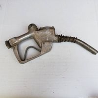 Full side view showing the shape, size, and handle of the vintage gas pump nozzle.