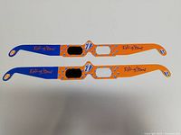 Top view of two pairs of 3D glasses showing orange and blue frames with Rolling Stones logos and concert branding