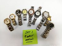 Nine men’s watches arranged in a row on white background