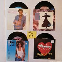 Top view of four vinyl 45 RPM records in original picture sleeves, displayed with note marked "Set G"