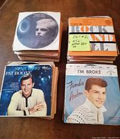 Four stacks of 45 RPM records with visible cover artwork of Pat Boone and Frankie Avalon, along with a note indicating approximately 220 45 RPM records in the lot.