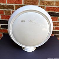 Front view showing the flat back and round shape with some surface wear.