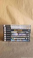 Stack of eight PS2 game cases showing titles on spines