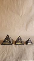 Front view of three pyramid paperweights showing Egyptian motif and graduated sizes