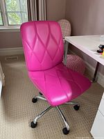 Front side view of the pink upholstered desk chair showing stitching pattern on seat and back.