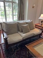 Front view of the sofa showing three seat cushions, three back cushions, and two smaller pillows