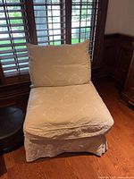 Front view of cream upholstered slipper chair with patterned fabric and cushioned backrest
