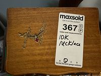 Necklace with MaxSold lot tag on wooden surface