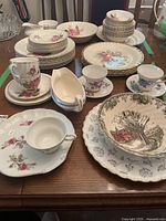 Table display showing multiple Royal Wessex china pieces including dinner plates, side plates, cups, saucers, serving bowl and platter, and various smaller serving pieces.