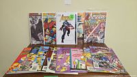 Photo displays approximately 15 comic books including Avengers, Spiderman, Simpsons, Sonic and others laid flat showing front covers.