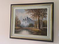 Framed landscape painting hanging on wall, showing entire artwork and frame.