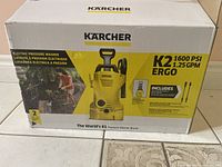Photo of the boxed Karcher K2 electric pressure washer showing model, PSI and flow rate.