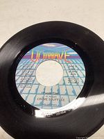 Top view of 45 RPM vinyl record 'Purple Flash' by Crème Soufflée on Uniwave label, showing vinyl surface and label details.