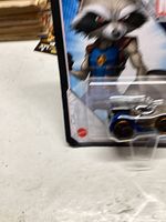 Photo showing Hot Wheels Marvel Rocket Raccoon toy car in original packaging with character artwork visible.
