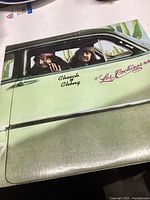 Front album cover showing Cheech & Chong in a green car with the title Los Cochinos.
