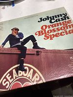 Front cover of Johnny Cash Orange Blossom Special vinyl record showing Johnny Cash sitting on a train car with clear album title text.