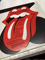 Vinyl record with the iconic Rolling Stones red tongue logo and track list visible on the label.