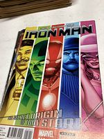 Photo showing Iron Man comic book titled 'The Secret Origin of Tony Stark' with five vertical character panels.