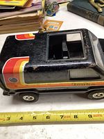 Side view of vintage Tonka van toy with visible colorful stripes and measuring tape showing approximately 7 inches length