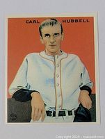 Front view of Carl Hubbell baseball card with orange background, uniform, and name at top.